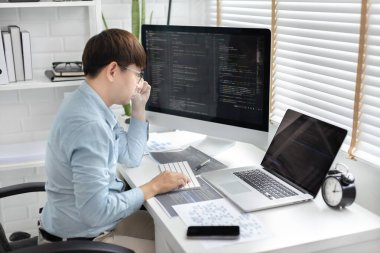 Profesyonel geliştirme programcıları, bilgisayar-laptop-tablet gibi çalışma ekipmanlarıyla bir masada otururlar. Web sitesi, HTML, javascript, Yazılım üzerinde çalışmak veya kod yazmak için.