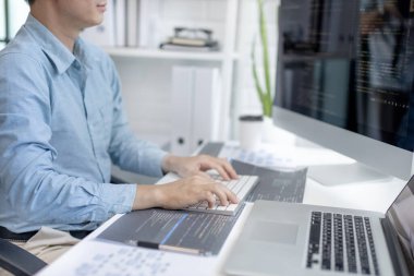 Profesyonel geliştirme programcıları, bilgisayar-laptop-tablet gibi çalışma ekipmanlarıyla bir masada otururlar. Web sitesi, HTML, javascript, Yazılım üzerinde çalışmak veya kod yazmak için.