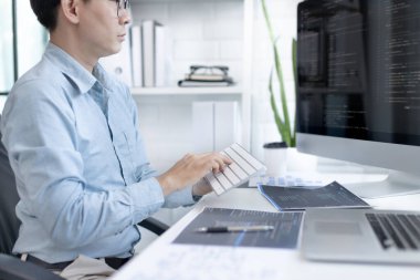 Profesyonel geliştirme programcıları, bilgisayar-laptop-tablet gibi çalışma ekipmanlarıyla bir masada otururlar. Web sitesi, HTML, javascript, Yazılım üzerinde çalışmak veya kod yazmak için.
