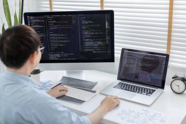 Profesyonel geliştirme programcıları, bilgisayar-laptop-tablet gibi çalışma ekipmanlarıyla bir masada otururlar. Web sitesi, HTML, javascript, Yazılım üzerinde çalışmak veya kod yazmak için.