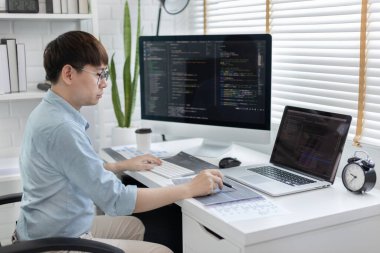 Professional development programmers are laying out a structure or draft on paper in preparation for coding on a computer, Write information or code for the website,  HTML, javascript, Software.