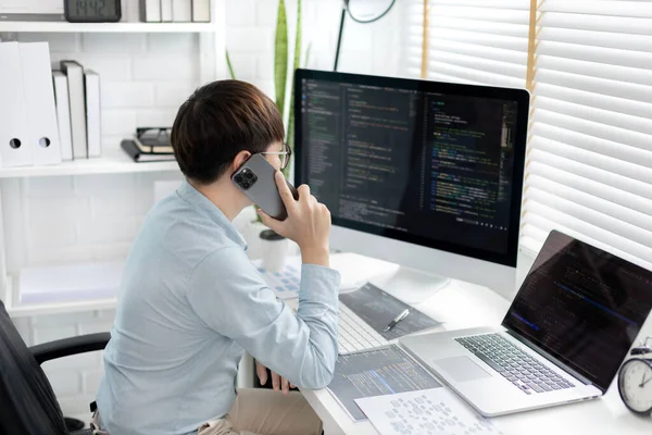 Professional development programmers are talking on the phone with their colleagues for website planning or programming on computers, Write information or code for website,  HTML, javascript, Software