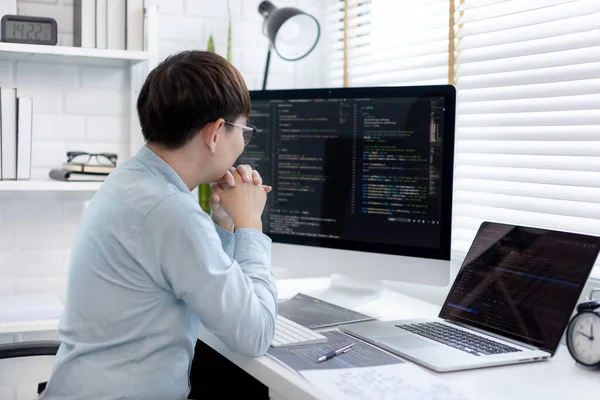 Profesyonel geliştirme programcıları, bilgisayar-laptop-tablet gibi çalışma ekipmanlarıyla bir masada otururlar. Web sitesi, HTML, javascript, Yazılım üzerinde çalışmak veya kod yazmak için.
