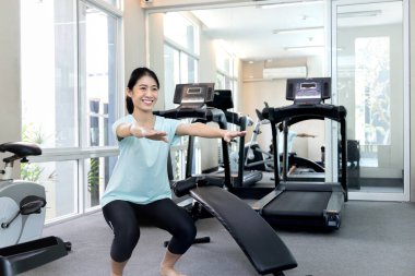 Beautiful and shapely Asian woman working out in the gym, Play exercise machine treadmill, Dumbbell, stretching, Hanging bar, Barbell, Cardio, Stretch, Woman warming up in the gym, Jump rope.