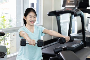 Beautiful and shapely Asian woman working out in the gym, Play exercise machine treadmill, Dumbbell, stretching, Hanging bar, Barbell, Cardio, Stretch, Woman warming up in the gym, Jump rope.