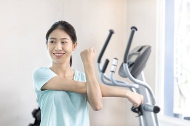 Beautiful and shapely Asian woman working out in the gym, Play exercise machine treadmill, Dumbbell, stretching, Hanging bar, Barbell, Cardio, Stretch, Woman warming up in the gym, Jump rope.