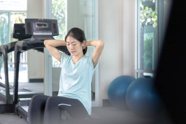 Beautiful and shapely Asian woman working out in the gym, Play exercise machine treadmill, Dumbbell, stretching, Hanging bar, Barbell, Cardio, Stretch, Woman warming up in the gym, Jump rope.