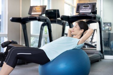 Beautiful and shapely Asian woman working out in the gym, Play exercise machine treadmill, Dumbbell, stretching, Hanging bar, Barbell, Cardio, Stretch, Woman warming up in the gym, Jump rope.