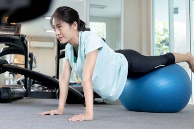 Beautiful and shapely Asian woman working out in the gym, Play exercise machine treadmill, Dumbbell, stretching, Hanging bar, Barbell, Cardio, Stretch, Woman warming up in the gym, Jump rope.