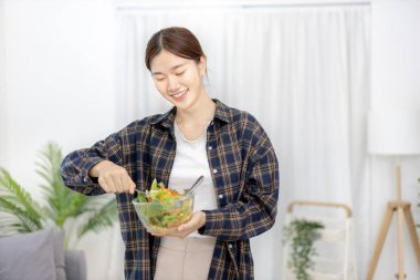 Ev mutfağında sebze salatası yapan Asyalı kadın çeşitli vitamin ve mineraller, yüksek lifli ve düşük kalorili diyetler, sağlıklı sebze salatası fikri, aperatif konsepti içeriyor..