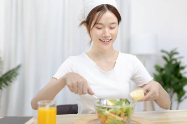 Ev mutfağında sebze salatası yapan Asyalı kadın çeşitli vitamin ve mineraller, yüksek lifli ve düşük kalorili diyetler, sağlıklı sebze salatası fikri, aperatif konsepti içeriyor..