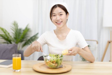 Ev mutfağında sebze salatası yapan Asyalı kadın çeşitli vitamin ve mineraller, yüksek lifli ve düşük kalorili diyetler, sağlıklı sebze salatası fikri, aperatif konsepti içeriyor..