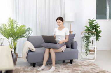 Beautiful Asian woman uses laptop to communicate work, Working from home at home happily, Freelancers work or learn in private rooms at home, Online communication, Home lifestyle.