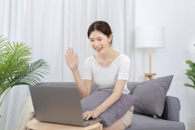 Beautiful Asian woman uses laptop to communicate work, Working from home at home happily, Freelancers work or learn in private rooms at home, Online communication, Home lifestyle.