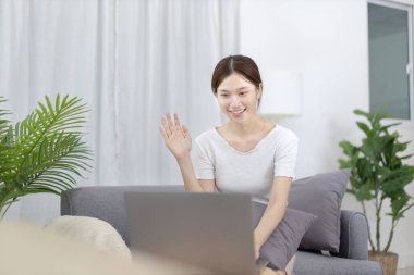 Beautiful Asian woman uses laptop to communicate work, Working from home at home happily, Freelancers work or learn in private rooms at home, Online communication, Home lifestyle.