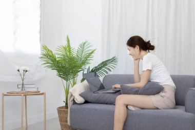 Beautiful Asian woman uses laptop to communicate work, Working from home at home happily, Freelancers work or learn in private rooms at home, Online communication, Home lifestyle.