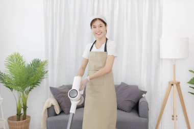Beautiful woman vacuuming the floor of her living room, Big cleaning in the house, Removes germs and dirt and deep stains, Housewife cleaning, Keeping her home clean, Domestic hygiene.