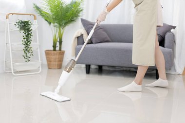 Beautiful woman mopping the floor of her living room, Big cleaning in the house, Removes germs and dirt and deep stains, Housewife cleaning, Keeping her home clean, Domestic hygiene.