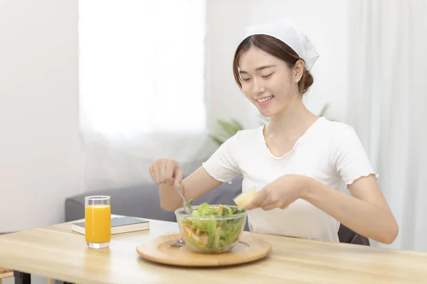 Asian woman making vegetable salad in her home kitchen, Vegetables contain a wide variety of vitamins and minerals, High-fiber and low-calorie diets, Healthy vegetable salad idea, Appetizer concept.