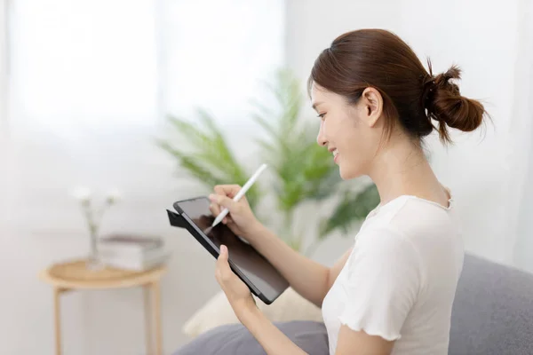 Asian Woman Sitting Sofa Tablet Looking Tablet Screen Relaxing Home — Stockfoto