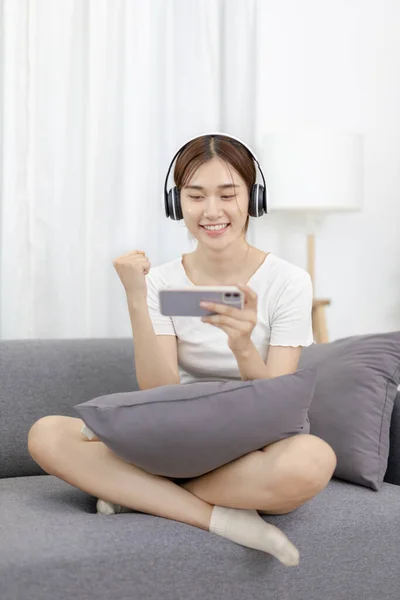 Woman play E-Sport games or streamers, Rejoices in victory, Male enjoying playing online games, Entertainment  or technology game trends, Fun holiday, Sitting on the sofa playing mobile games