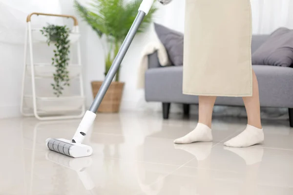 Beautiful woman vacuuming the floor of her living room, Big cleaning in the house, Removes germs and dirt and deep stains, Housewife cleaning, Keeping her home clean, Domestic hygiene.