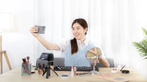 Beautiful woman with a social media influence is greeting the audience for recording vlog video live streaming, Showing how to make up and use cosmetics, Online business on concept of beauty bloggers.