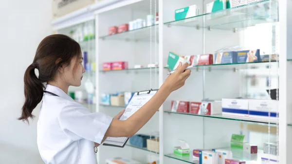 여성들은 고객들에게 방약을 공급하고 약사들은 약국에서 일하고 선반에는 약국의 Community — 스톡 사진