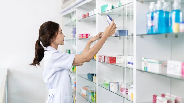 Pharmacist picks up pills on shelf from doctor\'s prescription, All kinds of generic household drugs and pharmaceutical products on the shelf , Administering medications as prescribed by the doctor.