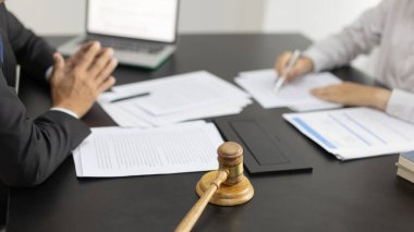Avukat ya da hakim, müvekkilinin mahkeme salonunda, yasal anlaşma belgelerinde ve iş hukuku davaları formlarında, adalet terazisinde, hukuk çekicinde, davalarda ve hukuki hizmetlerde yasal bir anlaşma imzalamasını öneriyor..