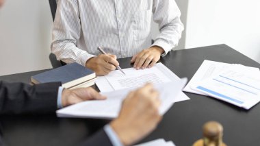 Avukat ya da hakim, müvekkilinin mahkeme salonunda, yasal anlaşma belgelerinde ve iş hukuku davaları formlarında, adalet terazisinde, hukuk çekicinde, davalarda ve hukuki hizmetlerde yasal bir anlaşma imzalamasını öneriyor..