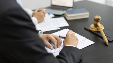Avukatlar veya hakimler, yasal ve adil anlaşma, hukuki ahlak ve bütünlük, adalet terazisi, hukuki çekiç, dava ve hukuk hizmetleri çerçevesinde belgeleri imzalıyorlar..