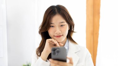 Finans çalışanları şirketin mali verilerini bir dizüstü bilgisayarda inceliyor ve sosyal mesafeler boyunca akıllı telefonları kullanarak iletişim kuruyor veya takımla sohbet ediyor, telefonda veya görüntülü konuşuyorlar..