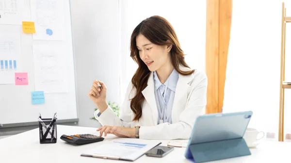 Asian business women are analyzing graphs, Financial statistics and calculating corporate returns in private offices, Market research reports and income statistics, Financial and Accounting concept.