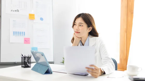 Asian business women are analyzing graphs, Financial statistics and calculating corporate returns in private offices, Market research reports and income statistics, Financial and Accounting concept.