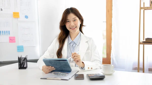 Businesswoman using laptop to work, Asian woman working in the office, Financial clerk or accountant with documents and equipment working on the desk, Using tablet for financial transactions.
