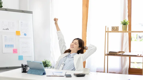 Female employee is doing a relaxing posture after a hard Midday\'s work, Happy women resting at work after work is finished, Fatigue is eased, Relax, Attractive, Stretch oneself, Stretch out the arms.
