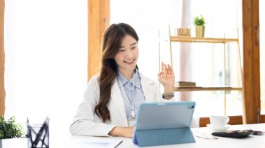 Çalışmak için dizüstü bilgisayar kullanan iş kadını, ofiste çalışan Asyalı kadın, evrak ve ekipmanlarla çalışan muhasebeci, mali işlemler için tablet kullanan.