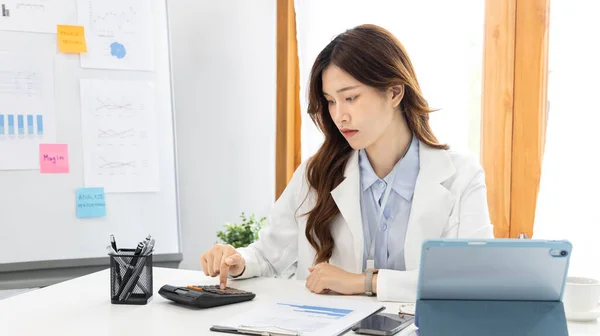 Asian business women are analyzing graphs, Financial statistics and calculating corporate returns in private offices, Market research reports and income statistics, Financial and Accounting concept.