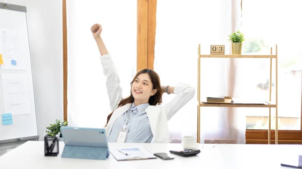 Female employee is doing a relaxing posture after a hard Midday\'s work, Happy women resting at work after work is finished, Fatigue is eased, Relax, Attractive, Stretch oneself, Stretch out the arms.