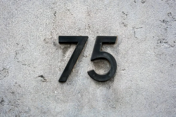 Czarny Dom Numer Siedemdziesiąt Pięć Betonowej Ścianie — Zdjęcie stockowe