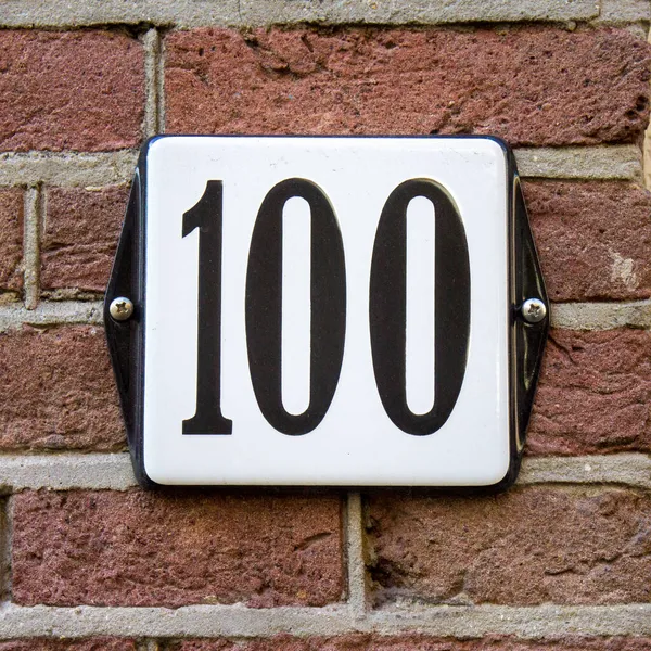 Dom Emaliowany Numer Sto 100 Ceglanej Ścianie — Zdjęcie stockowe