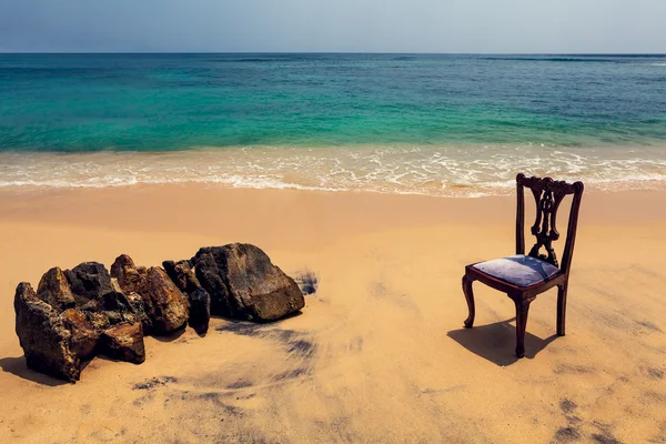 Stoel en stenen op tropisch strand — Stockfoto