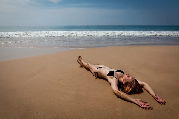 Menina deitada na praia tropical, banhos de sol — Fotografia de Stock