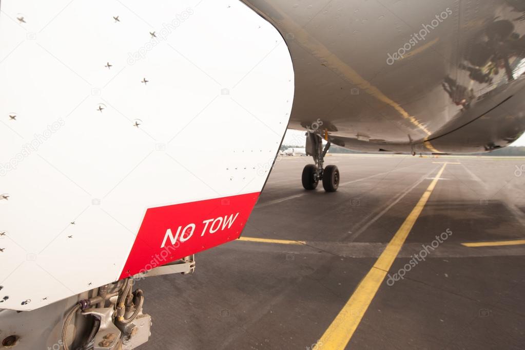 Sign NO TOW on undercarriage of airplane - jetplane waiting on r