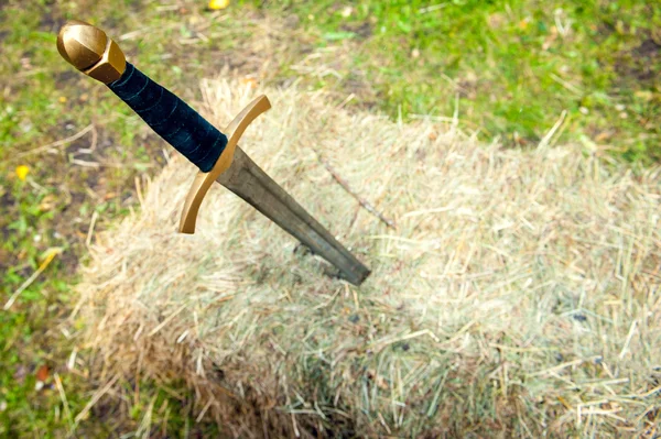 Medieval sword stuck in a pile of hay — Stock Photo, Image