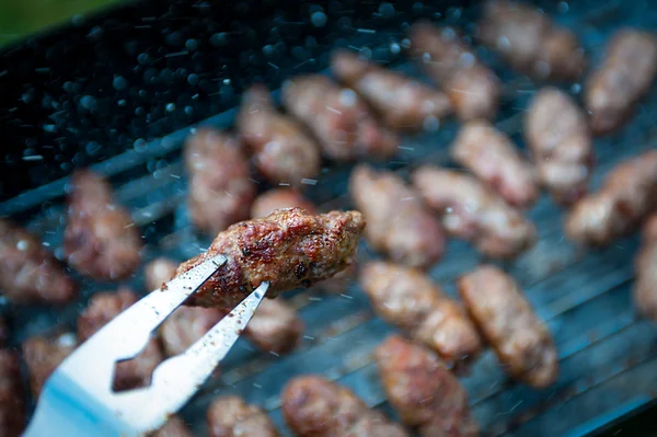 Albóndiga balcánica (cevap) en tenedor de barbacoa con fondo borroso — Foto de Stock