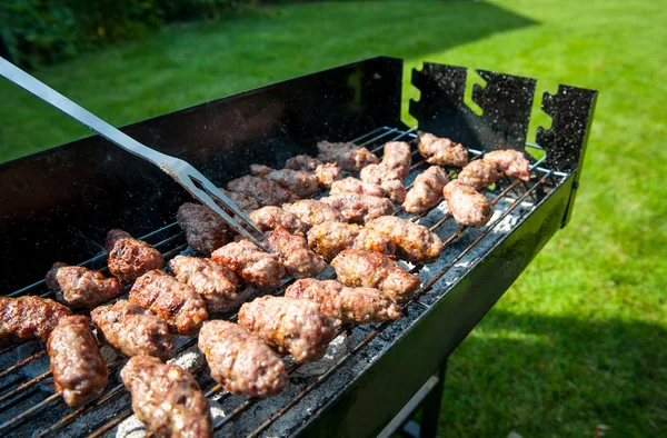 Balkan meatballs called cevapi on barbecue with BBQ fork — Stock Photo, Image