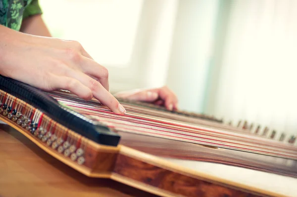 Genç kızın el müzik aletinin üzerinde oynamaya yakın çekim