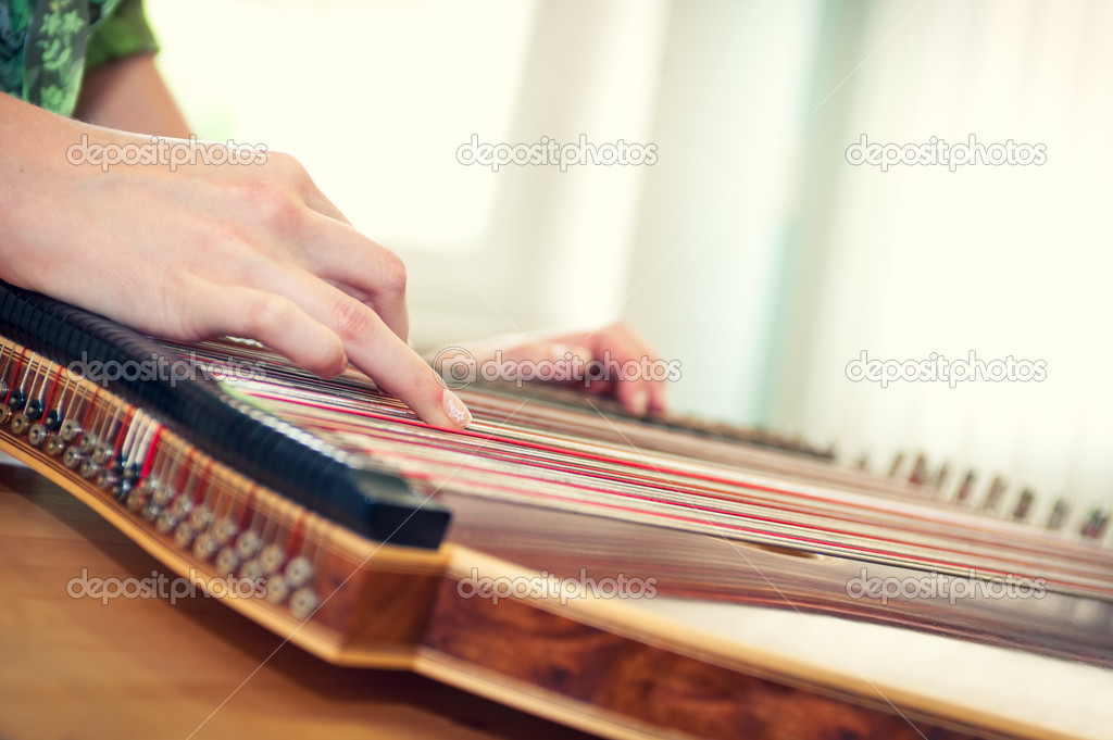 Close up of young girl's hand playing on zither